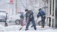 People clear a sidewalk during a winter snow storm in Philadelphia, Tuesday, Feb. 13, 2024. Parts of the Northeast were hit Tuesday by a snowstorm that canceled flights and schools and prompted warnings for people to stay off the roads, while some areas that anticipated heavy snow were getting less than that as the weather pattern changed.  (AP Photo/Matt Rourke)