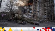 A Ukrainian police officer takes cover in front of a burning building that was hit in a Russian airstrike in Avdiivka, Ukraine, Friday, March 17, 2023. (AP Photo/Evgeniy Maloletka)