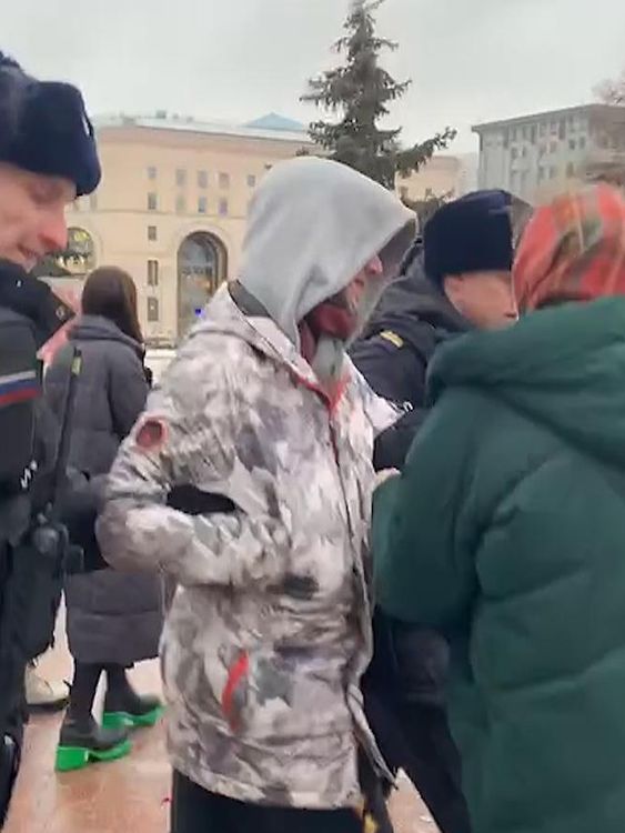 A woman pleads with police to let her friend go after he visited a memorial to Alexei Navalny