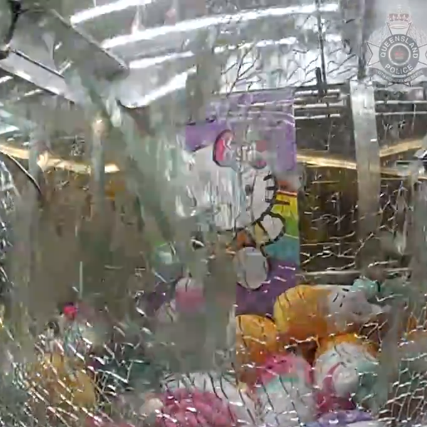 Police breaking glass on a toy claw machine to free Ethan, a three year old boy. Pic: Queensland Police
