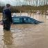 Man rescues driver from 4ft-high water - as emergency crew watches