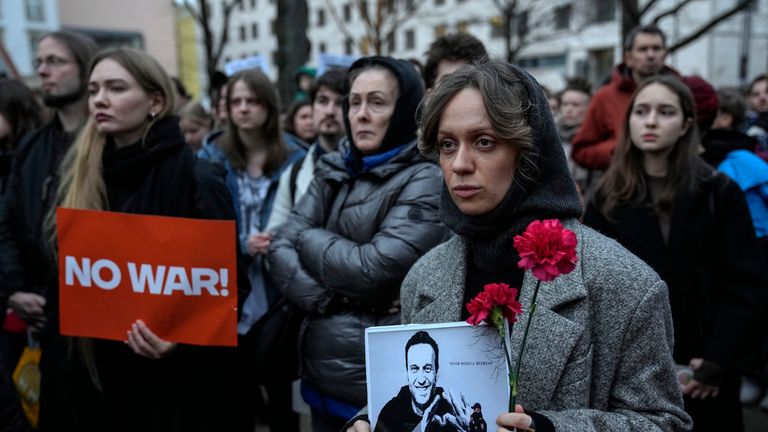2024年2月16日星期五，一名妇女在俄罗斯驻德国柏林大使馆前的抗议活动中拿着被监禁的俄罗斯反对派领导人阿列克谢·纳瓦尔尼的肖像。（美联社照片/易卜拉欣·诺鲁齐）