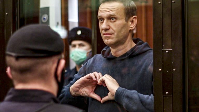 Alexei Navalny makes a heart gesture standing in a cage during a hearing in Moscow in 2021 
Pic: AP