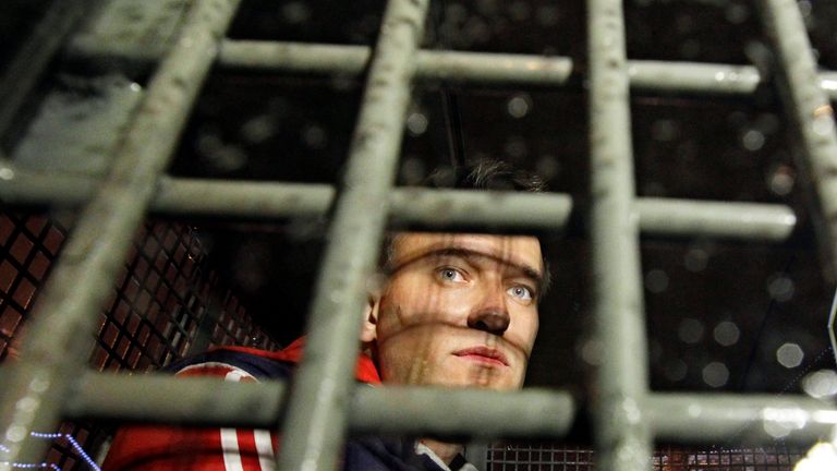 Alexei Navalny is seen behind the bars in the police van after he was detained during protests in Moscow in 2012
Pic:AP