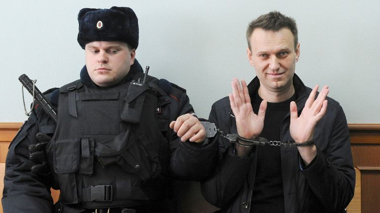 Alexei Navalny, right, poses for press as he sits handcuffed in court in Moscow, Russia in 2017
Pic: AP