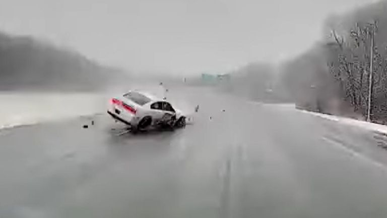 An ambulance has narrowly avoided an out-of-control car as it crashed  through barriers and rolled across a highway in Massachusetts.