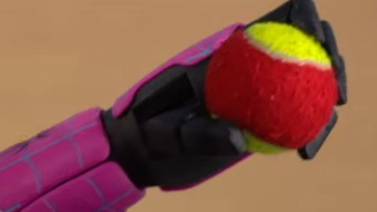 Prosthetic arm grabbing tennis ball