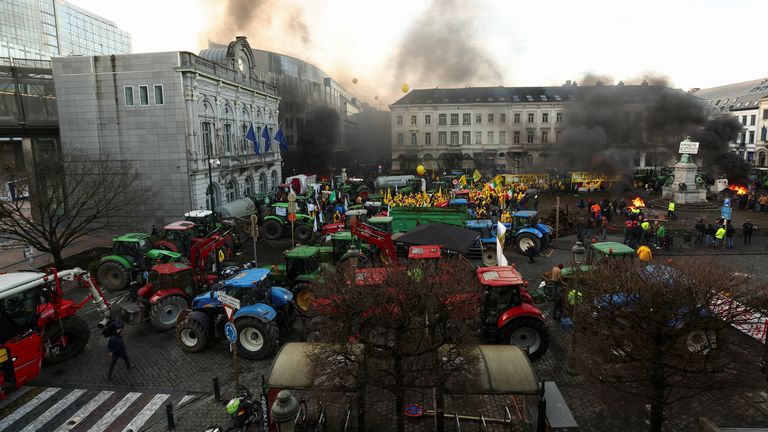 Smoke rises from a fire as tractors park up in Brussels. Pic: Reuters