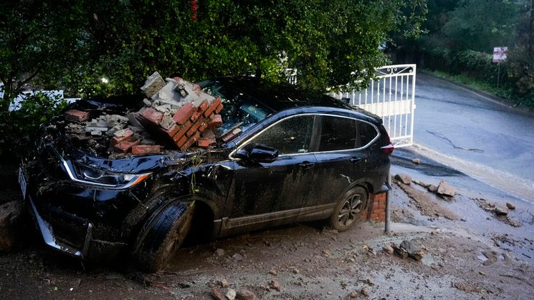 A car is damaged by debris from a storm Monday, Feb. 5, 2024, in Studio City, California. The second of back-to-back atmospheric rivers took aim at Southern California, unleashing mudslides, flooding roadways and knocking out power as the soggy state braced for another day of heavy rains. (AP Photo/Marcio Jose Sanchez)