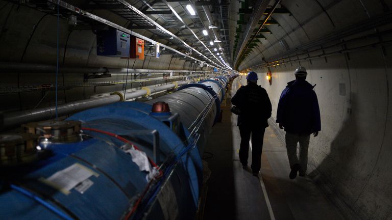 CERN staff walk in the LHC (Large Hadron Collider) tunnel during a visit at the Organization for Nuclear Research (CERN) in Meyrin, near Geneva April 10, 2013. As hundreds of engineers and workers start two years of work to fit out the giant LHC particle collider to reach deep into unknown realms of nature, CERN physicists look to the vast machine to unveil by the end of the decade the nature of the mysterious dark matter that makes up a quarter of the universe and perhaps find new dimensions of