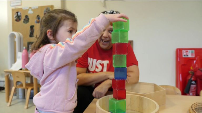 A child plays with a staff member at nursery