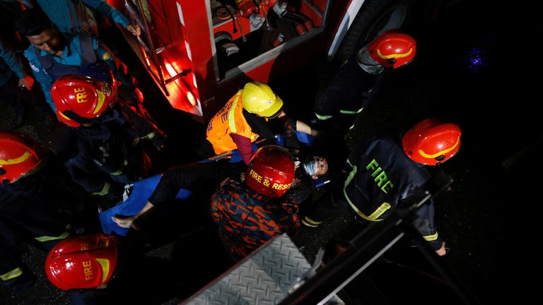 Firefighters carry out a body from the fire. Pic: Reuters