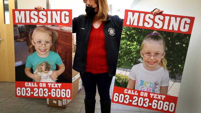 A police official holds two reward posters that show missing Harmony Montgomery in Jan 2022. Pic: John Tlumacki/The Boston Globe via AP