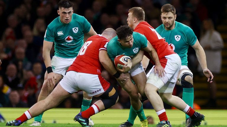 Ireland&#39;s Hugo Keenan is tackled by Wales&#39; Dillon Lews and Tommy Reffell