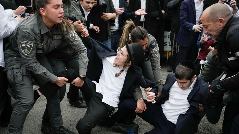 Israeli police officers disperse ultra-Orthodox Jewish men and boys blocking a road during a protest against the country&#39;s military draft in Jerusalem, Monday, Feb. 26, 2024. (AP Photo/Leo Correa)