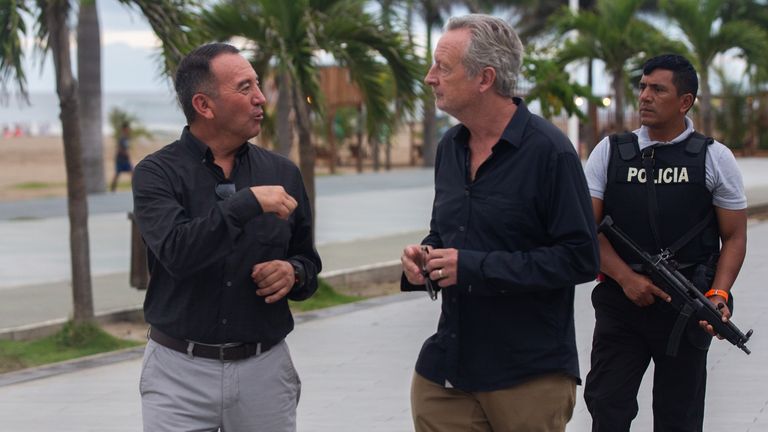 Javier Buitron, governor of Esmeraldas, talks to Stuart Ramsay as his bodyguard walks behind