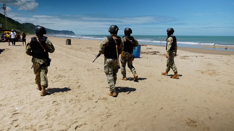Heavily armed marines patrol the beach