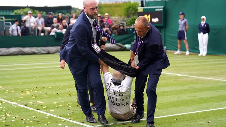 A Just Stop Oil protester is carried off court 18 after throwing confetti on to the grass during Katie Boulter�s first-round match against Daria Saville on day three of the 2023 Wimbledon Championships at the All England Lawn Tennis and Croquet Club in Wimbledon. Picture date: Wednesday July 5, 2023.