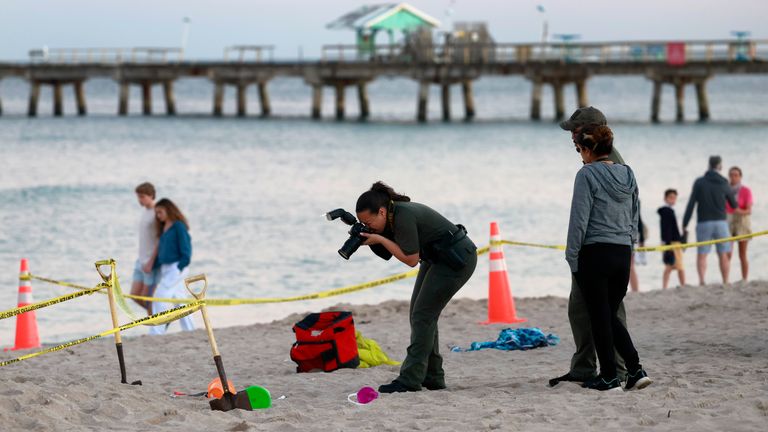 Investigators on the beach in Lauderdale-by-the-Sea.
Pic: South Florida Sun-Sentinel/AP
