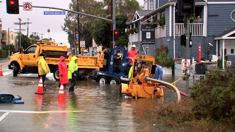 Workers pump flood water from the street surrounding the Inn at Playa del Rey, after heavy rains hit Southern California, in Los Angeles, California, U.S., February 5, 2024, as seen in this scree grab taken from a video. REUTERS/Sandra Stojanovic