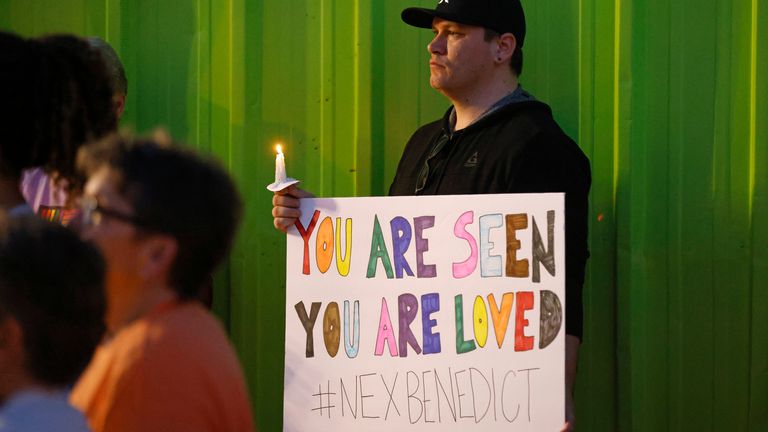 Kody Macaulay holds a sign during a candlelight service for Nex Benedict, a nonbinary teenager who died one day after a fight in a high school bathroom, at Point A Gallery, Saturday, Feb. 24, 2024, in Oklahoma City. (Nate Billings/The Oklahoman via AP)