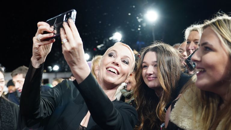 Olivia Colman takes selfies with fans as she arrives for the world premiere of Wonka at the Royal Festival Hall in London. Picture date: Tuesday November 28, 2023.

