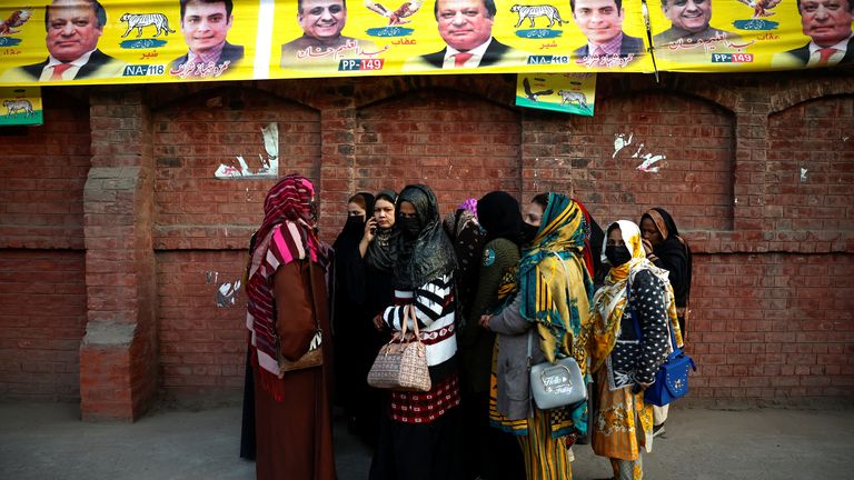 Women wait outside a polling station to start voting on general election day, in Lahore, Pakistan, February 8, 2024. REUTERS/Navish Chitrakar