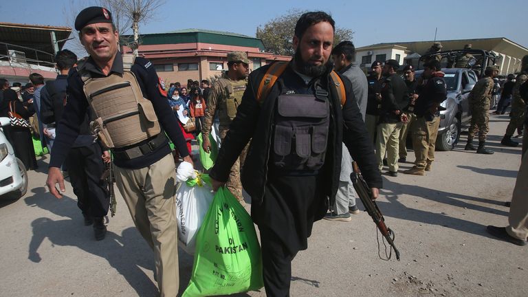 Police officers help members of polling staff to carry polling material. Pic: AP
