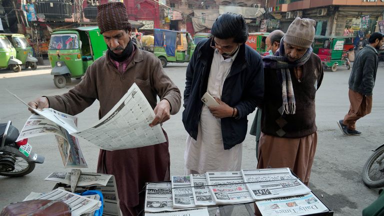 People read morning newspaper to know about the early results of parliamentary elections at a stall in Lahore, Pakistan, Friday, Feb. 9, 2024. The results of Pakistan&#39;s elections were delayed a day after the vote that was marred by sporadic violence, a mobile phone service shutdown and the sidelining of former Prime Minister Imran Khan and his party. (AP Photo/K.M. Chaudary)