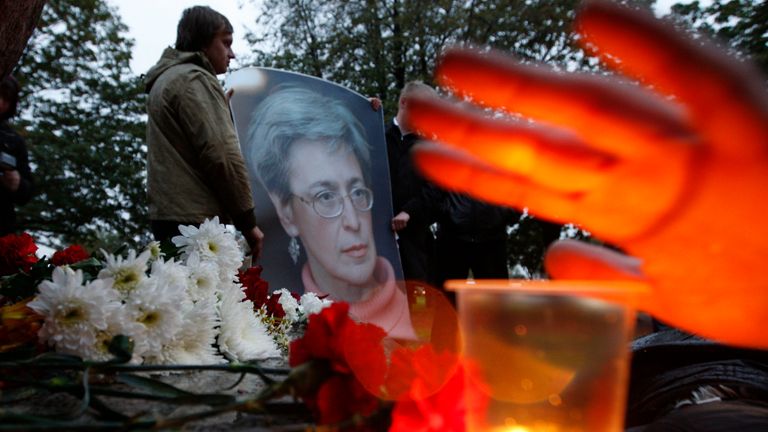 A man holds a portrait of the killed journalist Anna Politkovskaya as a woman lights up a candle during a commemorative rally in St.Petersburg, October 7, 2009. Three years after the murder of Politkovskaya, her family voiced doubts on Tuesday about the guilt of two men accused of a role in her killing and the Kremlin&#39;s will to catch the main suspects. REUTERS/Alexander Demianchuk (RUSSIA CRIME LAW CONFLICT POLITICS)

