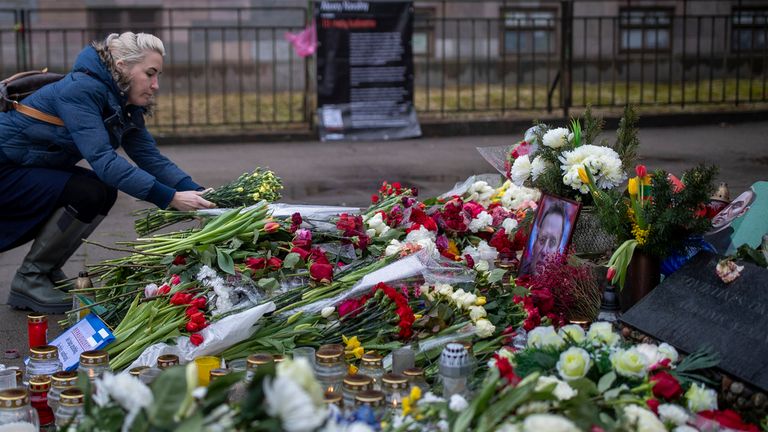 A woman lays flowers paying the last respect to Alexei Navalny at the at the monument to the victims of soviet occupation in Vilnius, Lithuania, Saturday, Feb. 17, 2024. Russian authorities say that Alexei Navalny, the fiercest foe of Russian President Vladimir Putin who crusaded against official corruption and staged massive anti-Kremlin protests, died in prison. He was 47. (AP Photo/Mindaugas Kulbis)