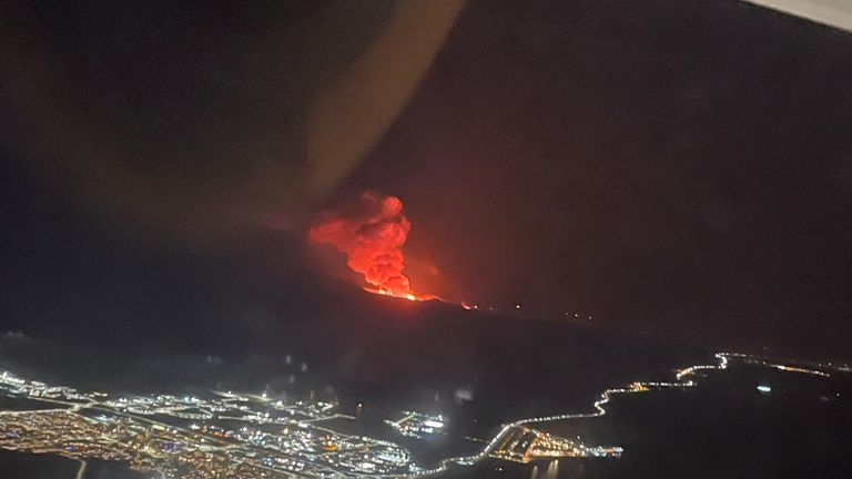 Smoke rises from a volcano on Reykjanes Peninsula as it erupts, as seen from a plane taking off from a Reykjavik airport, Iceland.
Pic: @BryonyMathew/@UKinIceland Reuters
