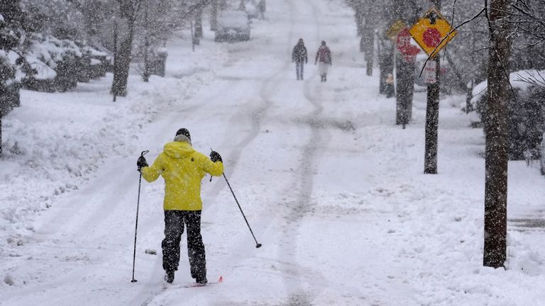 Nelson Taylor, of Providence, R.I., left, uses cross-country skis while making his way along a residential street, Tuesday, Feb. 13, 2024, in Providence. Parts of the Northeast have been hit by a coastal storm that&#39;s dumping snow and packing strong winds in some areas, while others aren&#39;t getting as much snow as anticipated. (AP Photo/Steven Senne)