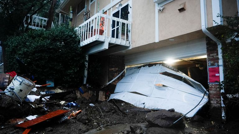 A garage door is damaged by a storm on a home, Monday, Feb. 5, 2024, in Studio City, California. The second of back-to-back atmospheric rivers took aim at Southern California, unleashing mudslides, flooding roadways and knocking out power as the soggy state braced for another day of heavy rains. (AP Photo/Marcio Jose Sanchez)