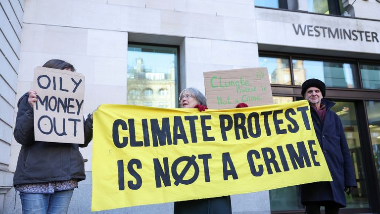 Climate change protesters hold signs outside Westminster Magistrates&#39; Court, on the day of Greta Thunberg&#39;s trial.
Pic: Reuters