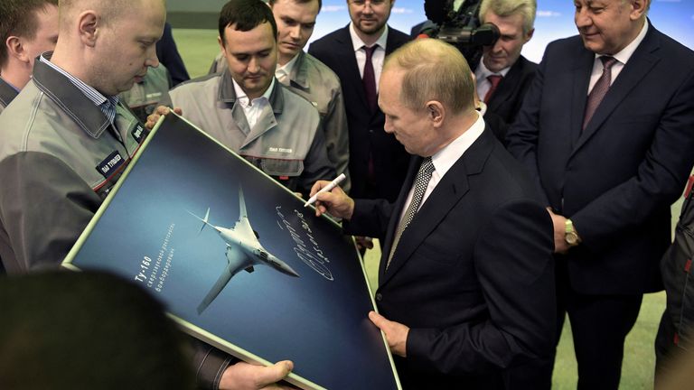 Vladimir Putin signs a picture of a TU-160M nuclear bomber. Pic: Reuters
