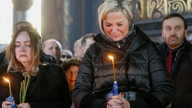 Maria Maksakova (2nd R), widow of Russian former lawmaker Denis Voronenkov who was recently killed by an assailant, and Russian former parliamentarian Ilya Ponomarev (R) attend a burial service at a cathedral in Kiev, Ukraine, March 25, 2017. REUTERS/Valentyn Ogirenko
