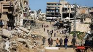 Palestinians walk past the ruins of houses in Gaza.
Pic Reuters