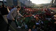 People place flowers at a makeshift memorial in front of the Crocus City Hall on the western outskirts of Moscow, Russia, Monday, March 25, 2024. The four men charged with the massacre at a Moscow theater have been identified by the Russian government as citizens of Tajikistan, some of the thousands who migrate each year from the poorest of the former Soviet republics to scrape out marginal existences. (AP Photo/Alexander Zemlyanichenko)