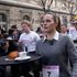 Waiters and waitresses balance croissant and cup of water on tray in Paris race