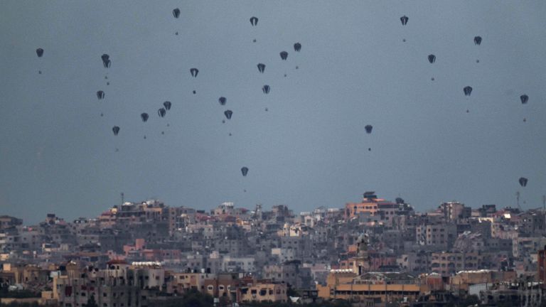 Parachutes drop supplies into the northern Gaza Strip, as seen from southern Israel. Pic: AP