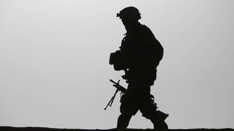 A British soldier is silhouetted as he walks with his machine gun on a roof top of a residential house in the village Qari Sahib, Nad Ali district, Helmend province, southern Afghanistan, Monday, Feb. 15, 2010 (AP Photo/Altaf Qadri)