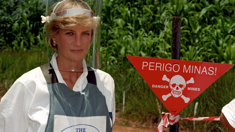 Pictured in 1997, Princess Diana stands next to a warning sign on the edge of a minefield in Angola during a visit to the work of the British Red Cross. Image: PA/John Stilwell. 