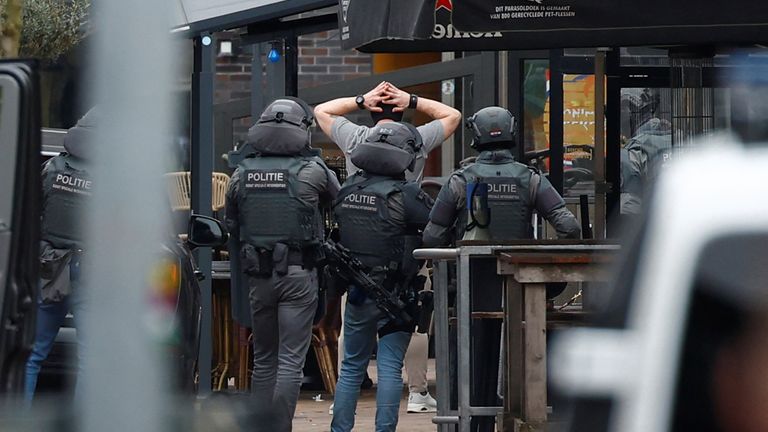 Dutch police officers detain a person near the Cafe Petticoat, where several people are being held hostage in Ede, Netherlands March 30, 2024. REUTERS/Piroschka Van De Wouw