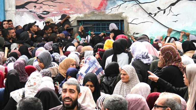 Palestinians gather to receive aid outside an UNRWA warehouse in Gaza City.
Pic: Reuters