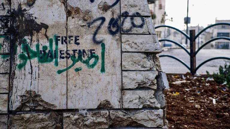 'Free Palestine' graffiti on a damaged building.
