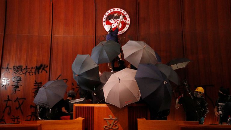 FILE - Protesters deface the Hong Kong logo at the Legislative Council to protest against the extradition bill in Hong Kong on July 1, 2019. A Hong Kong court sentenced 12 people Saturday, March 16, 2024 to prison over the storming of the city...s legislative council building at the height of the anti-government protests in 2019. (AP Photo/Vincent Yu, File)
