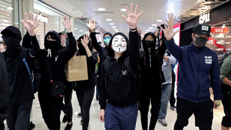 Anti-government demonstrators raise their hands as they walk past shops during a protest in Sheung Shui shopping mall in Hong Kong, China, December 28, 2019. REUTERS/Lucy Nicholson
