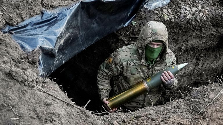 A Ukrainian serviceman holds an artillery shell as he prepares to fire a howitzer towards Russian troops at a position in a frontline near the town of Kreminna
Pic: Reuters