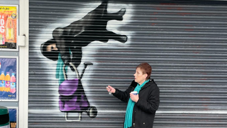 Anne Hughes, next to the mural of the incident outside the Best One convenience store in Rhondda Cynon Taf. Pic: Tee2Sugars
